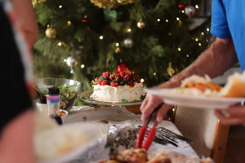 Winterliches Dessert mit Beeren vor einem Weihnachtsbaum